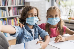 kids-taking-selfie-library-while-wearing-medical-masks.jpg